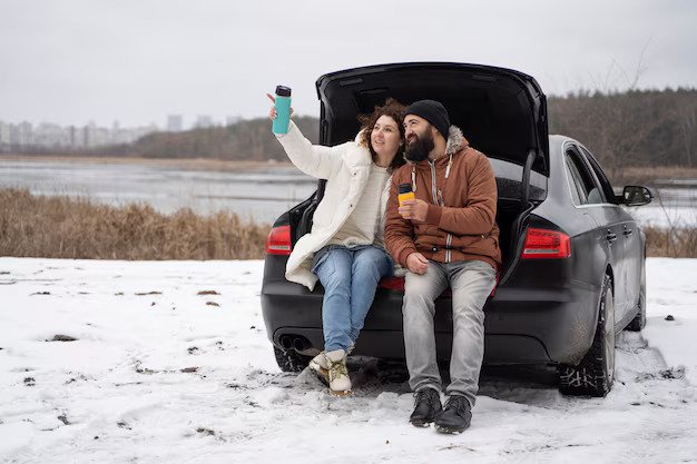 Couple sitted on car backside and enjoy the snow Weather