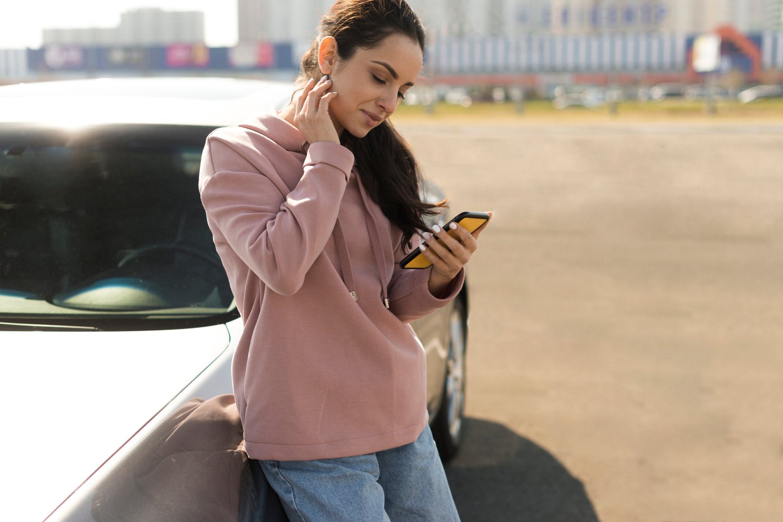 Confident female driver leaning against car after successful road test