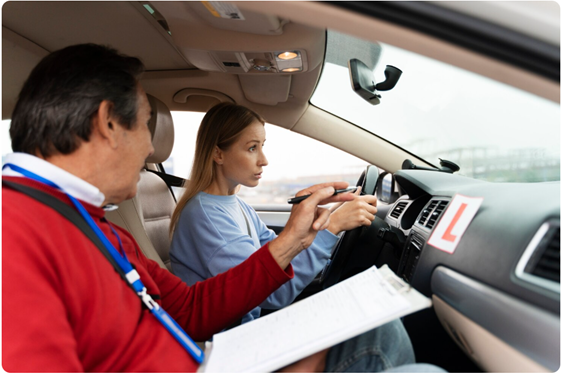 Male driving instructor teaching female student driver
